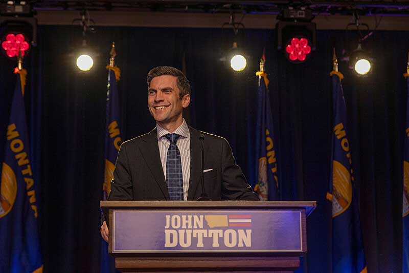 Jamie Dutton standing at a podium and smiling