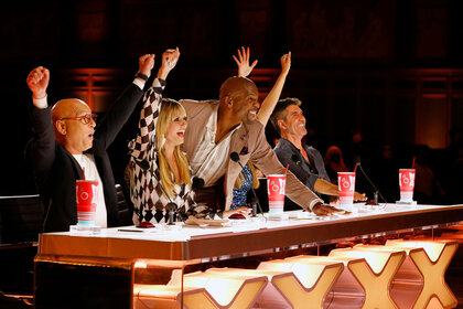 Americas Got Talent judges cheering on a performer with the arms in the air