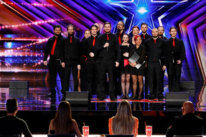 14 members of the Dremeka Choir standing onstage