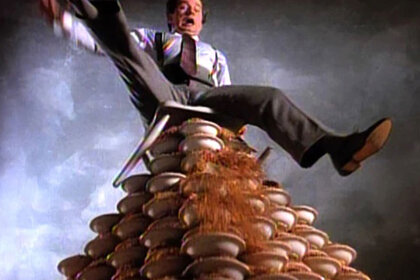 Phil Hatman sitting on a mountain of cereal bowls about to topple over