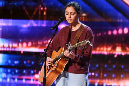 Singer Amanda Mammana playing guitar on the AGT stage