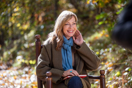 Allison Janney sitting in a chair outside