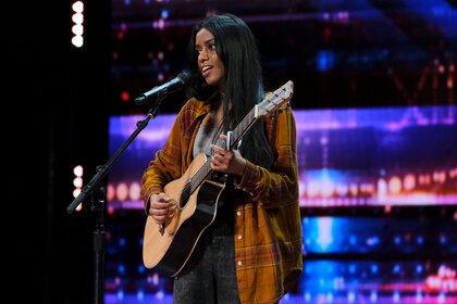 Debii Dawson singing while playing guitar