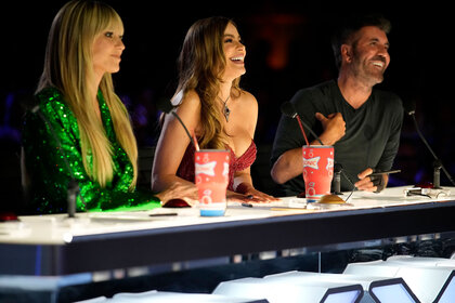 Heidi Klum, Sofia Vergara, and Simon Cowell seated behind the judge's table