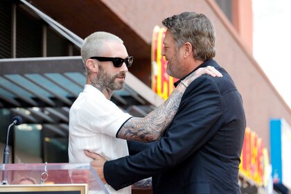 Adam Levine and Blake Shelton embrace.