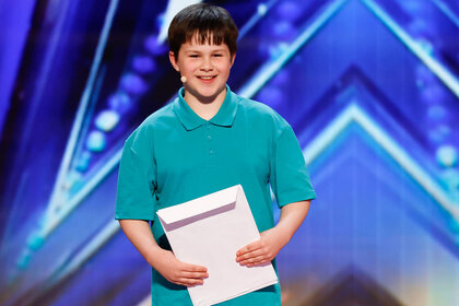 Ryland smiles while standing on the America's Got Talent stage