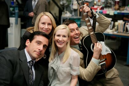 Michael, Holly, Angela and Andy holding a guitar during a scene from The Office.