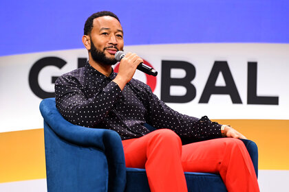 John Legend speaking at an event.