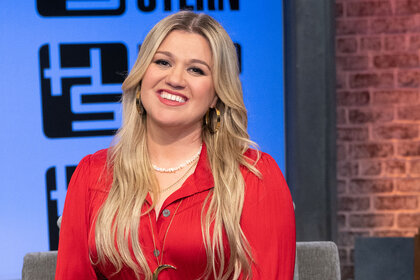 Kelly Clarkson smiles while looking into the camera