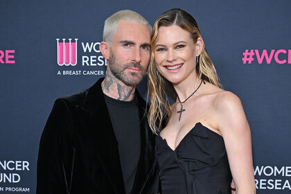 Adam Levine and Behati Prinsloo pose on a red carpet