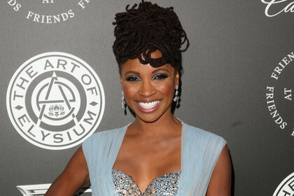 Shanola Hampton smiles on the red carpet while wearing a light blue dress