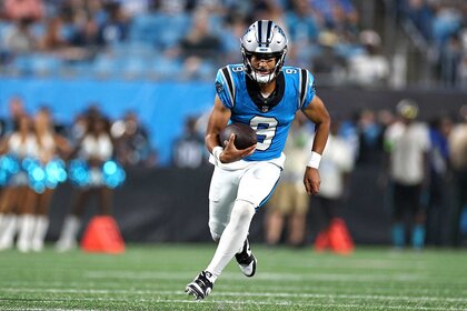 Carolina Panthers Bryce Young carrying the ball for yardage.