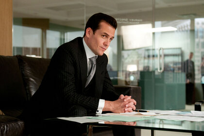 Harvey Spector (Gabriel Macht) sits at a desk in a scene from Suits