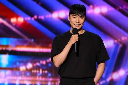 Yu Hojin, wearing a black shirt, on stage holding a mic.