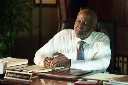 Letts (Richard Roundtree) sits behind a desk looking pensive