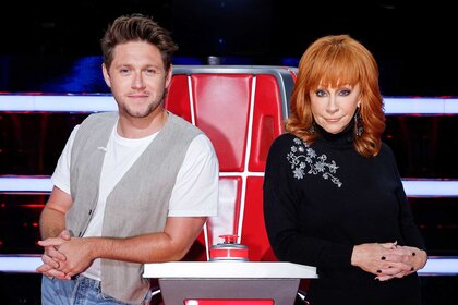 Niall Horan and Reba McEntire pose together at their coaches chair on The Voice episode 2410