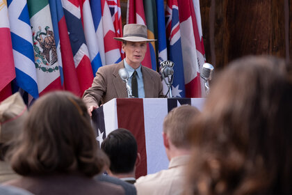 J. Robert Oppenheimer stands at a podium in Oppenheimer