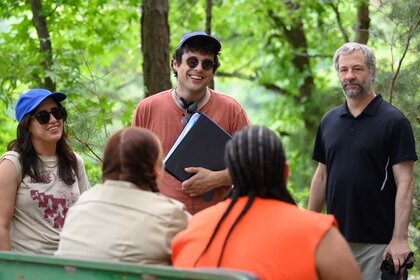 Albertina Rizzo, Paul Briganti, and Judd Apatow standing in front of a group of people in a forest.