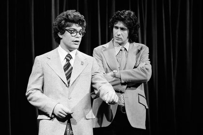 Al Franken and Tom Davis stand onstage during the "Improvisation" skit