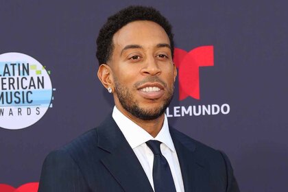 Ludacris smiles in a suit.