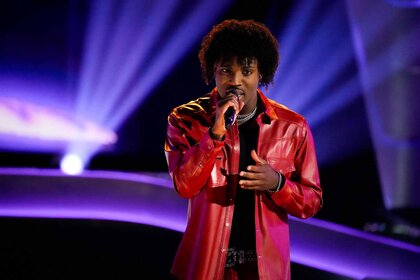 Rletto sings in a red jacket in Season 25 Episode 4 of The Voice.