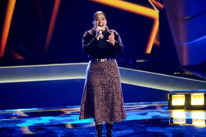 Mafe sings in a skirt in Season 25 Episode 4 of The Voice.