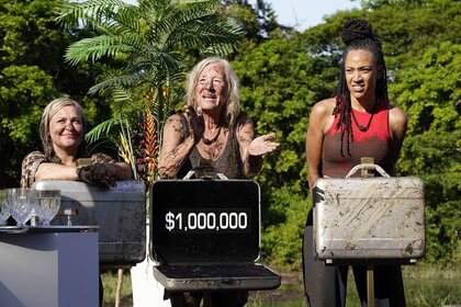 Amy McCoy, Kim Mattina, and Stephanie Mitchell stand behind briefcases in Deal or No Deal Island Episode 101.