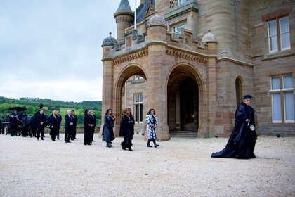 Alan Cumming and The Traitors Season 2 cast march outside the castle during Season 2 Episode 4.