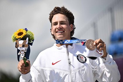 Jagger Eaton holds up flowers and a bronze medal at the Tokyo 2020 Olympic Games.