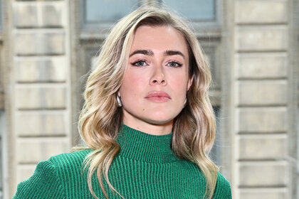 Melissa Roxburgh attends a fashion show in a green sweater