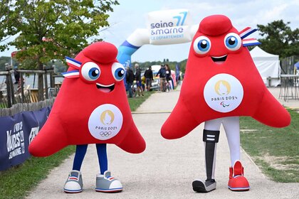 An Olympic Phryge mascot (L) and a Paralympic Phryge mascot pose together.