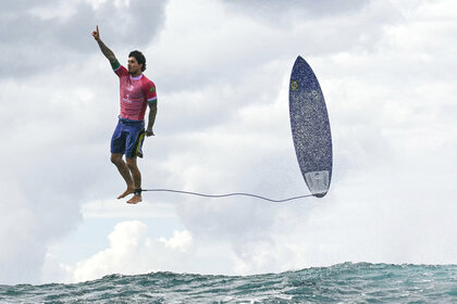 Gabriel Medina flies up in the air after catching a large wave at the 2024 Olympics