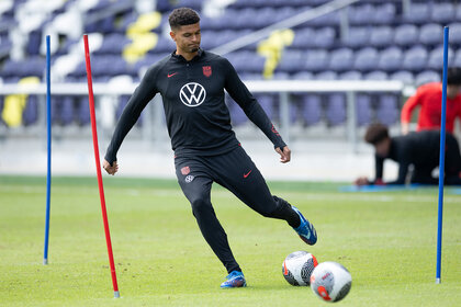 Miles Robinson on the Olympics 2024 Us Soccer Team kicks a soccer ball on the pitch