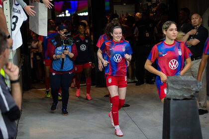 Rose Lavelle runs and enters the field for a soccer match