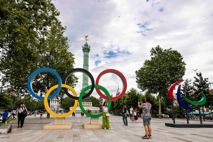 Visitors take photos next to Olympic and Paraolympic rings in paris