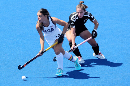 Amanda Golini playing field hockey against an opponent.