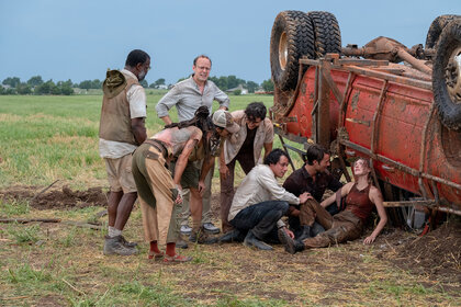 The cast of twisters tend to Kate next to a flipped over car in Twisters