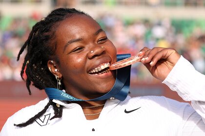 Veronica Fraley bites her medal at the track and field olympic trials