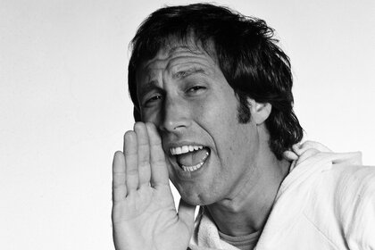 Chevy Chase holds his hand up to his face during a photoshoot for saturday night live