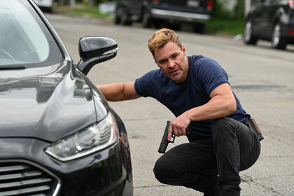 Officer Adam Ruzek (Patrick John Flueger) ducks behind a car