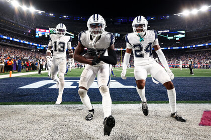 Some of the Dallas Cowboys celebrate at the end zone during a football game