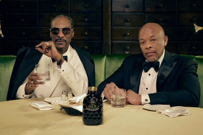 Dr. Dre and Snoop Dogg sit at a table with a bottle of Still Gin