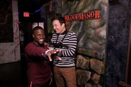 Kevin Hart and Jimmy Fallon stand in a haunted house