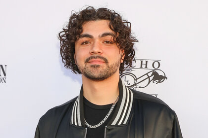 Adam Irigoyen wears a black and white jacket on the red carpet