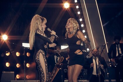 Dolly Parton and Miley Cyrus perform together onstage.