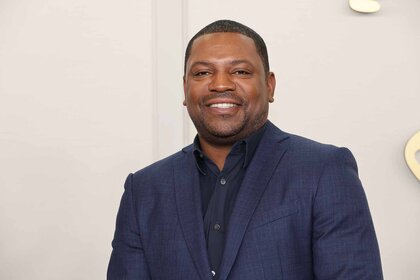 Mekhi Phifer smiles in a navy blazer.