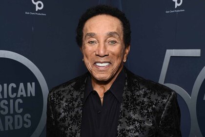 Smokey Robinson smiles in a jacquard jacket.