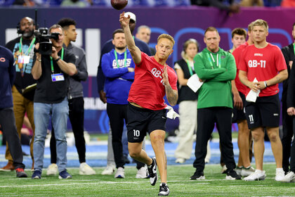 A quarter back from south carolina throws a football during the NFL Combine