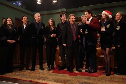 Melissa McCarthy, Paul Rudd, Tom Hanks, Tina Fey, John Mulaney, Martin Short, Jimmy Fallon, Emma Stone, Kristen Wiig, Alec Baldwin, and Scarlett Johansson standing on a stage.