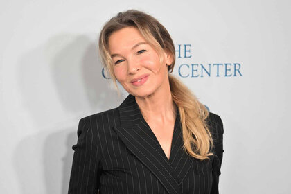 Renee Zellweger smiles in a black blazer.